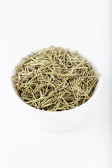 Dried rosemary in white bowl on white background. Dried rosemary isolated on white.