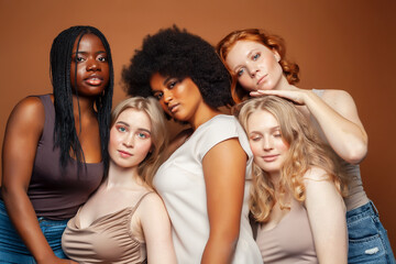 young pretty caucasian, afro, scandinavian woman posing cheerful together on brown background, lifestyle diverse nationality people concept
