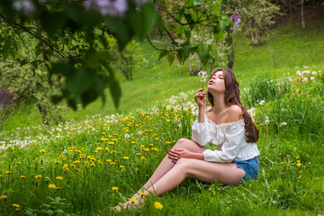 Spring happy woman sitting outdoor in summer park. Healthy breathing concept, unity with nature. Spring air.