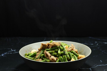 Spicy Fried and stirred cutting fresh green bean (Yardlong bean) with chicken and chilly paste serving on the plate. Famous appetizer menu in Chinese restaurant. 