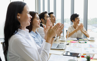 Group of five diversity businessmen, two men and three women sitting at meeting desk and clap their hands for the speaker.