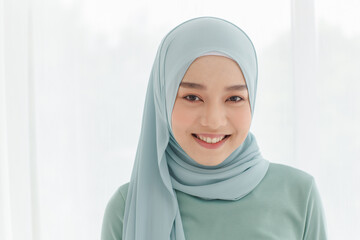 Portrait of 30s beautiful Muslim girl wearing hijab traditional religious cloth looking to camera with a lovely smile on white background