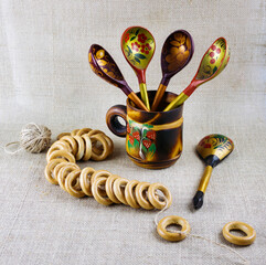 Russian wooden painted tableware: spoons in a mug on a light background. Preparations for the...