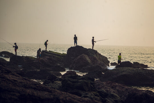 India goa arambol fishermen on the rocks