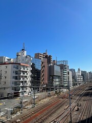 looking down from a bridge over railway in Shibuya, Tokyo, Japan on a sunny day blue sky