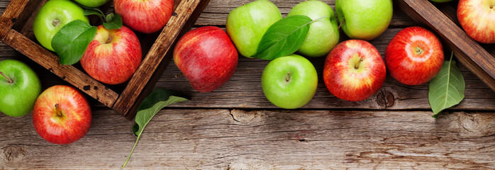 Green and red apples in wooden boxes