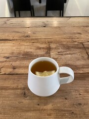 Cup of hot ginger drink with sliced lemon on a wooden table in Shibuya, Tokyo, Japan