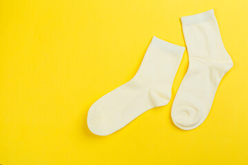 Top view of a pair of colored socks on a yellow background. Clothing in the form of socks.
