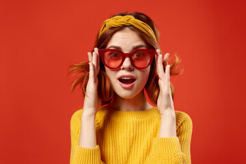 pretty woman in yellow sweater red glasses fashionable clothes close-up red background