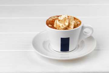 Cup of coffee with whipped cream on white table