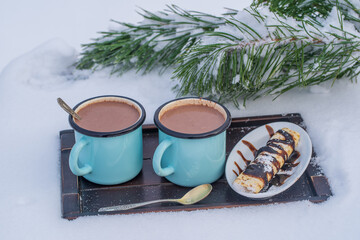 Obraz na płótnie Canvas Two hot cocoa drink on a bed of snow and white background, close up