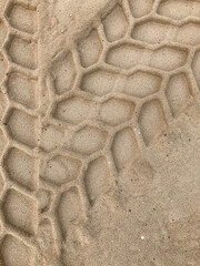 Sand with car tire marks, tracks in sand, close up