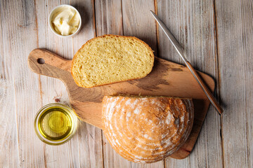 Top view on cut loaf of olive oil bread on the wooden table with butter