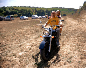 A couple of young people on a motorcycle.