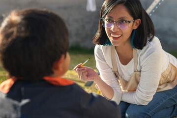A young woman smiling and painting in the yard
