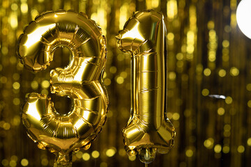 The golden number 31 thirty one is made from an inflatable balloon on a yellow background. One of...