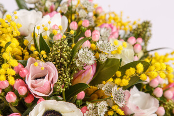 Floral arrangement with mimosa and animons on gray background 