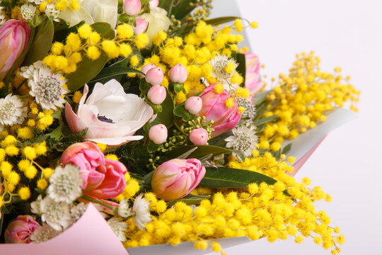 Floral arrangement with mimosa and animons on gray background 