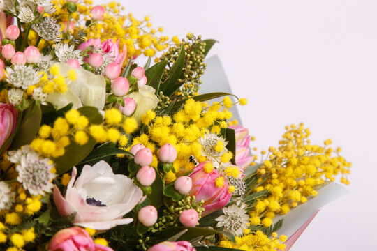 Floral arrangement with mimosa and animons on gray background 