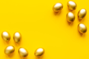 Golden eggs on yellow. Easter decoration background. Top view