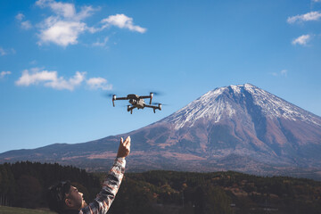 Hand catching drone aircraft in blue sky and Mt. Fuji background. - 412091913