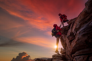 Young asian couple climbing up on the mountain,hiking and team work concept. - 412092178