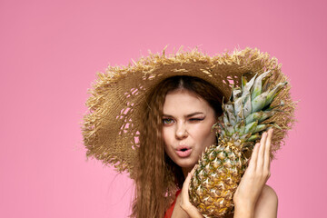 woman in straw hat on us fruits fun cosmetics pink background