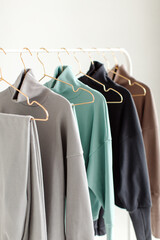 Stylish and comfortable clothes for teenagers hang on a hanger. Clothes for convenience on a white background