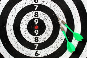 Darts game with two green darts lying