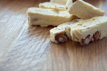 Sweet biscotti cookies with nuts and a striped kitchen towel on wooden background. Side vie