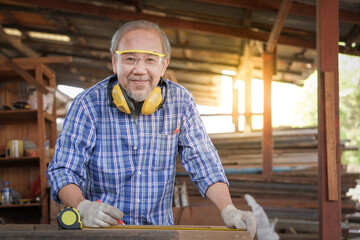 Carpenter men work on the measurements of wood in a carpentry shop.