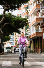 40-year-old woman riding her electric bicycle through the streets of the city