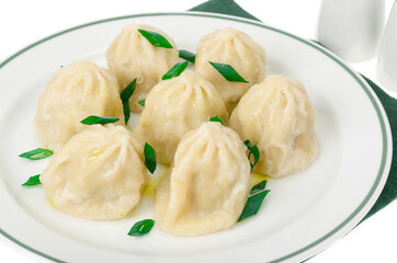 White plate with boiled khinkali, green onions.