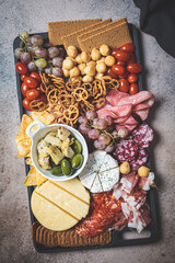 Charcuterie and cheese platter.  Appetizers tray with assorted meat, cheese, fruits, olives and crackers.