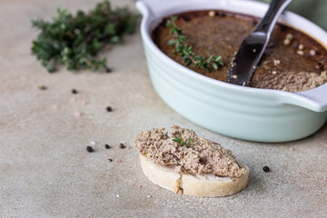 Ciabatta with chicken or turkey liver pate with thyme, concrete background.