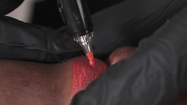 Close up demonstration of permanent make up on lips. Beautician applying coloring pigment on African woman's lips. Cosmetic tattooing procedure in beauty salon
