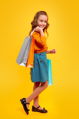 Happy schoolgirl in casual outfit enjoying shopping