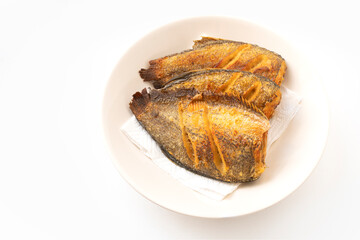 Deep-fried fishes or Snakeskin gourami fish in the round disk on white background with clipping path. The fish is called Pla Salid or Slid in Thailand language.