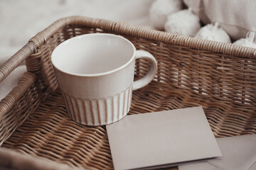 Set of cards, invitation and envelope in boho interior on a wooden tray