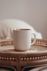 White ceramic mug in boho interior on a wicker tray