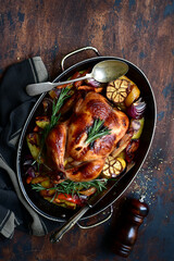 Oven baked chicken with roasted vegetables in a skillet pan. Top view with copy space.