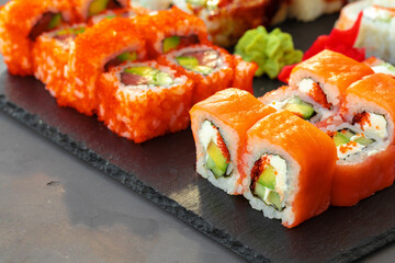 Set of various sushi rolls served on gray background