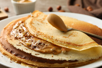 Plate of crepes with peanut butter and nuts, close up