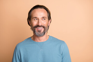 Photo portrait of man looking at blank space isolated on pastel beige colored background