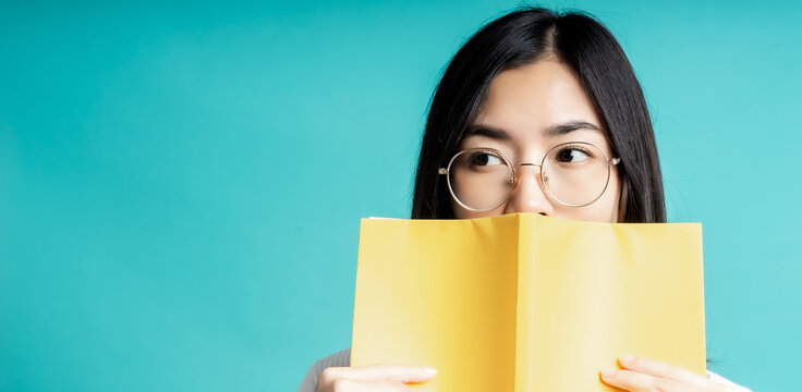 Beautiful Of Portrait Young Asian Woman Happiness Relax Standing Reading Book On Isolated Blue Background At Home, Girl Happy Study Content Literature, Education And Lifestyle Concept.