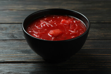 Bowl of beetroot soup on wooden background