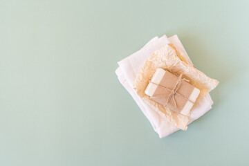 Craft paper, cotton fabric, soap, over green background. Zero waste, natural organic bathroom tools. Plastic free life. Ecological skin care, body treatment concept