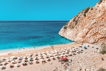 Fototapeta na wymiar Very famous and popular among tourists and vacationers Kaputas beach on the Mediterranean coast of Turkey. Panoramic view of sea and sun loungers in the narrow gorge