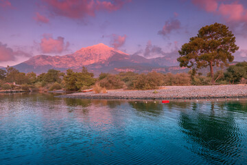 Panoramic view of the illuminated by the rising sun Tahtali mountain with the sea. Concept of holidays and natural attractions in Turkey in the Kemer and Tekirova region