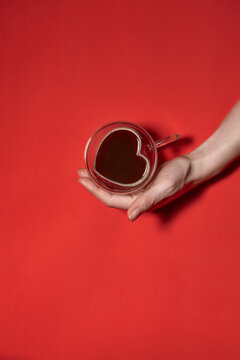 Valentines day hearts background. Woman Holding Hot Cup Of Coffee, With Heart Shape Stock Photo. Beautiful decorative heart shaped on red background, valentines day concept
